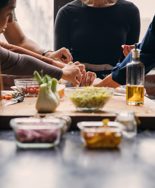 Menschen unterschiedlicher Herkunft kochen gemeinsam – symbolisch für Führung auf Augenhöhe und gelebte Inklusion in der Praxis
